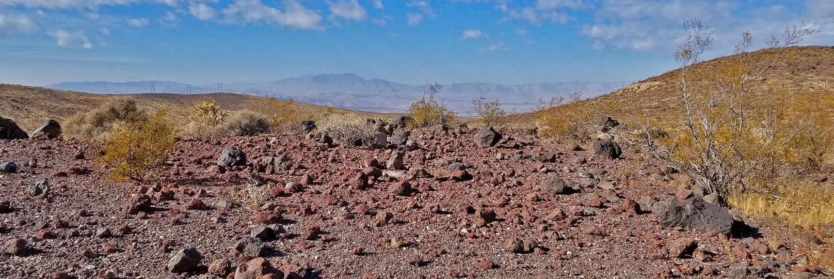 Lots of Volcanic Rock in the Hills. Las Vegas Valley and Rainbow Mountains Backdrop | McCullough Hills Trail in Sloan Canyon National Conservation Area, Nevada